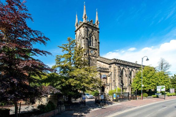 Trinity Theatre The outside of trinity Theatre a gothic church building set against a bright blue sky with trees in the foreground.